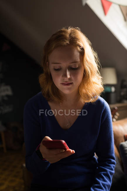 Close-up of woman using her mobile phone at home — Stock Photo