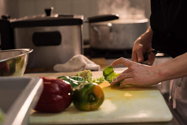 Nahaufnahme des Küchenchefs, der Gemüse in der Großküche zerkleinert — Stockfoto