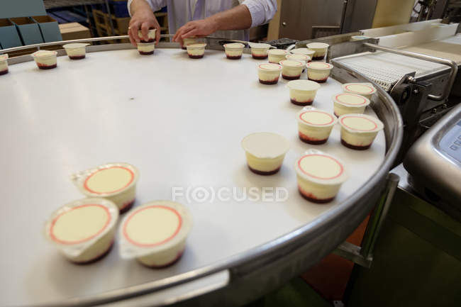 Sezione media degli alimenti di imballaggio del lavoratore vicino alla linea di produzione — Foto stock