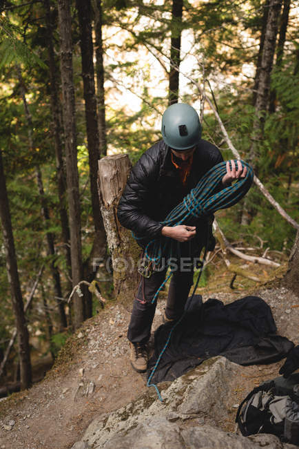 Determined rock climber preparing himself to climb the cliff — Stock Photo