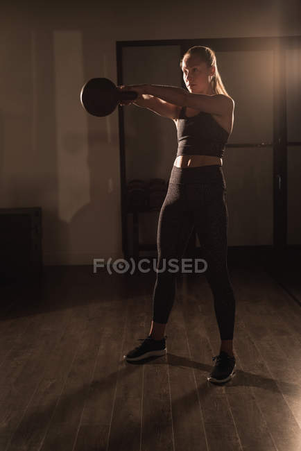 Жінка робить вправи з чайником у спортзалі — стокове фото
