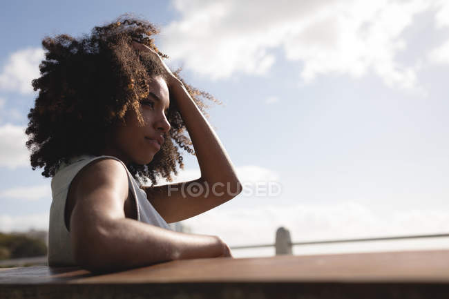 Mulher bonita sentada perto da praia em um dia ensolarado — Fotografia de Stock