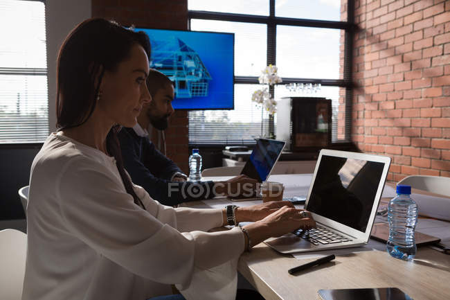 Бізнес-колеги, що працюють на ноутбуці в офісі — стокове фото