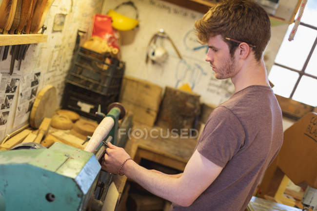 Ferramenta de afiação de carpinteiro masculino na máquina na oficina — Fotografia de Stock