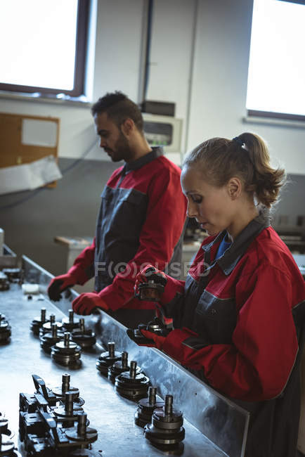 Deux travailleurs vérifient les pièces de la machine en usine — Photo de stock
