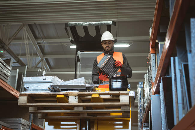 Trabalhador masculino verificando parte da máquina na fábrica — Fotografia de Stock