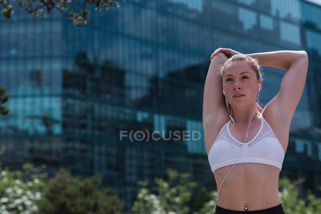 Junge sportliche Frau dehnt sich auf der Straße — Stockfoto