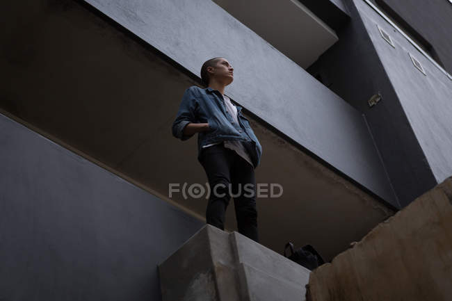 Thoughtful young man standing in balcony — Stock Photo