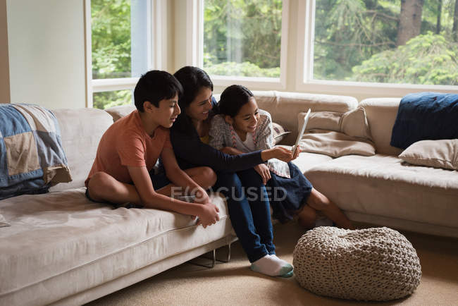 Mère et les enfants ayant appel vidéo sur ordinateur portable dans le salon à la maison — Photo de stock