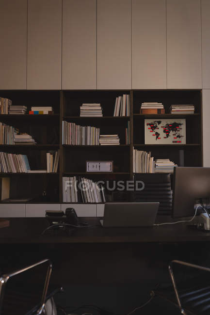 Modernes Bücherregal und Schreibtisch mit Bürostühlen. — Stockfoto