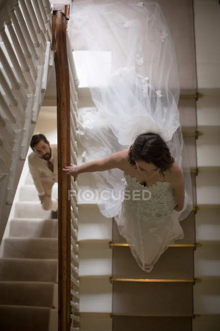 Наречений і наречений ходять по сходах вдома — стокове фото