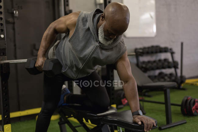Soulèvement déterminé de l'homme âgé avec haltère dans un studio de fitness
. — Photo de stock