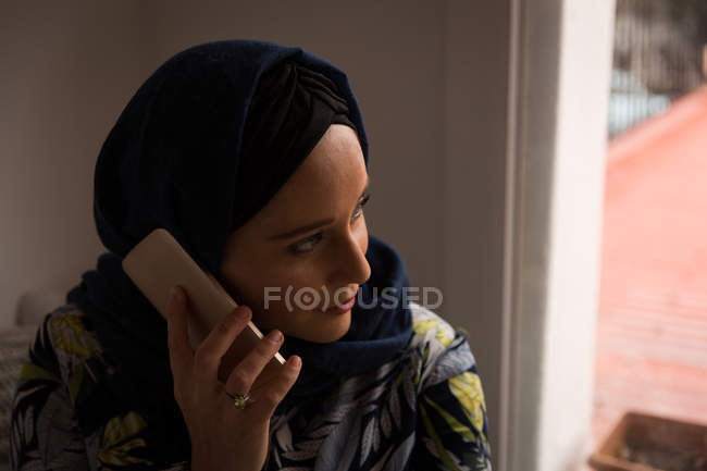 Mulher muçulmana falando ao telefone em casa — Fotografia de Stock