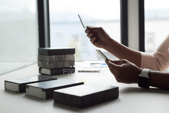 Executiva examinando lajes na mesa no escritório — Fotografia de Stock