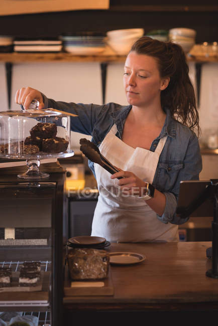 Beautiful waitress working at counter in cafe — Stock Photo