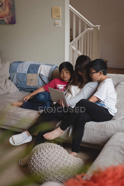 Мати і діти мають відеодзвінок на ноутбук у вітальні вдома — стокове фото