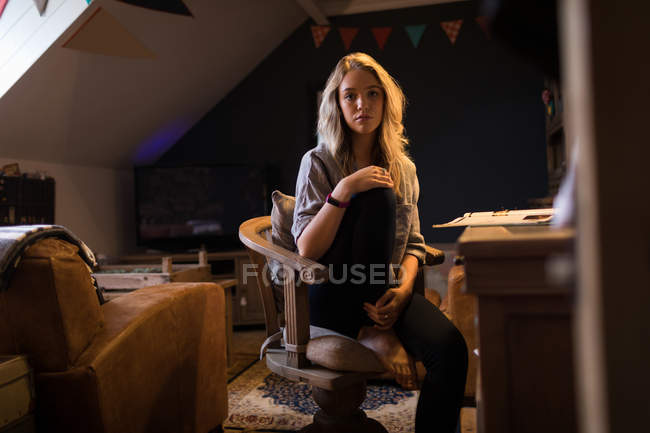 Портрет молодой женщины, сидящей на стуле — стоковое фото