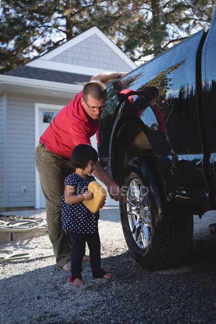 Pai e filha lavar carro com esponja em um dia ensolarado — Fotografia de Stock