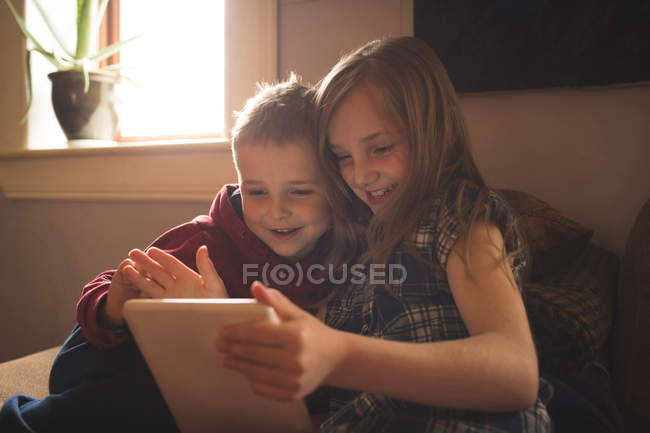 Feliz irmão usando tablet no sofá em casa — Fotografia de Stock
