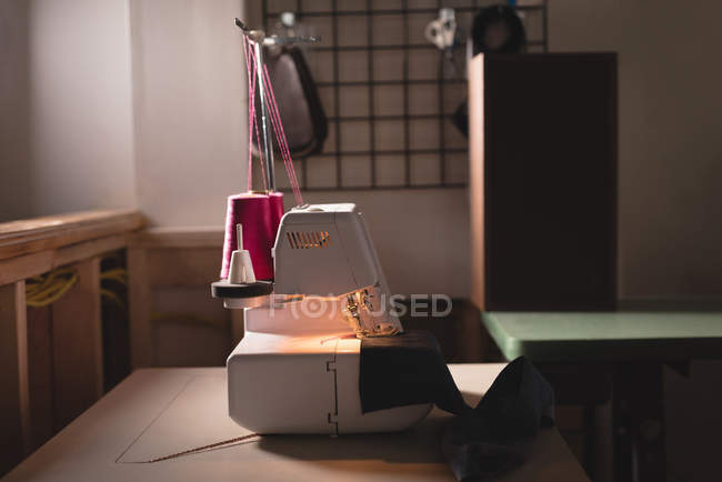 Máquina de coser en la mesa en el estudio de diseñadores - foto de stock