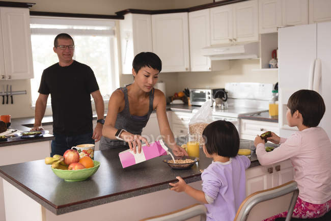 Сім'я снідає за столом на кухні — стокове фото