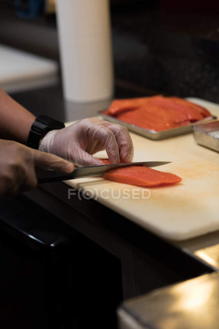 Шеф-кухар філе риби на кухні ресторану на дошці — стокове фото
