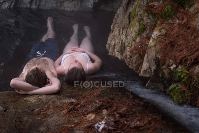Couple relaxant dans une source chaude pendant l'hiver — Photo de stock