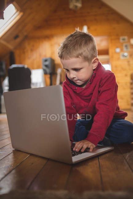 Симпатична дитина використовує ноутбук на підлозі вдома — стокове фото
