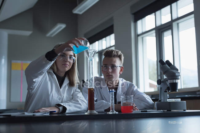 Studenti universitari in esperimento chimico in laboratorio — Foto stock