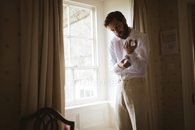 Groom se vestindo em casa perto da janela — Fotografia de Stock