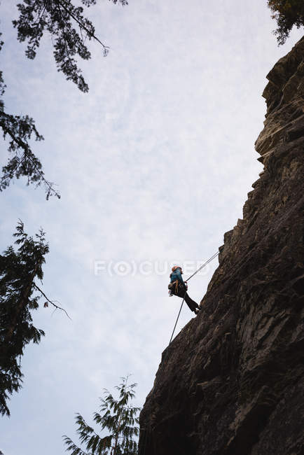 Blick in den niedrigen Winkel des Bergsteigers, der die felsige Klippe erklimmt — Stockfoto