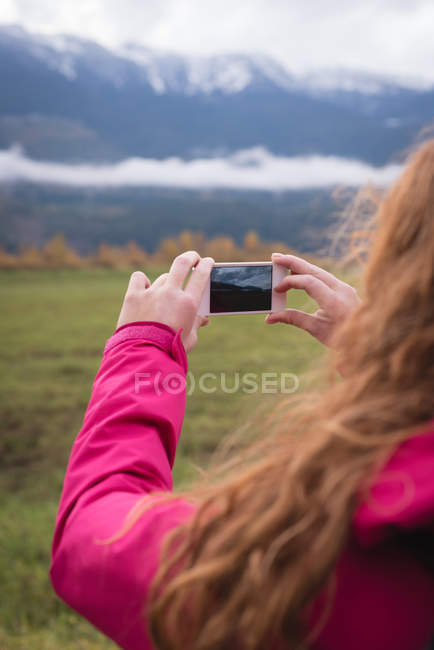 Close-up de mulher fotografar montanhas cobertas de neve e paisagem — Fotografia de Stock