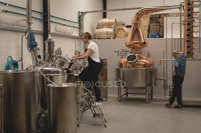 Trabalhadora do sexo feminino máquina de verificação de destilaria na fábrica — Fotografia de Stock