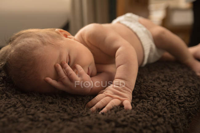 Bebé recién nacido relajándose en la manta marrón en casa
. - foto de stock