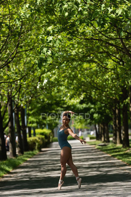 Jovem dançarina de balé dançando na estrada — Fotografia de Stock