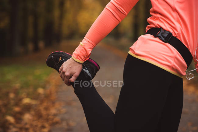Low section of woman performing stretching exercise in forest — Stock Photo