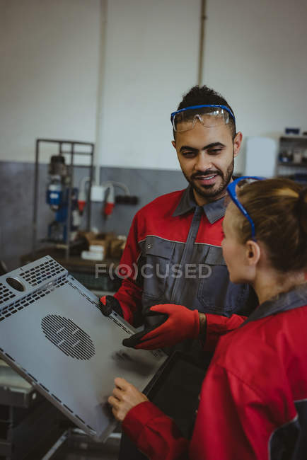 Two worker discussing over machine board in factory — Stock Photo