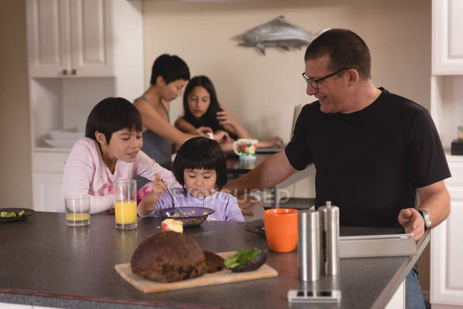 Famiglia che fa colazione a tavola in cucina — Foto stock
