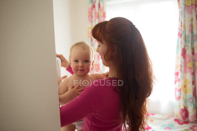 Mather holding her baby girl at home — Stock Photo