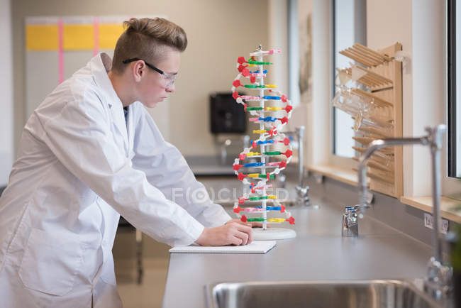 Teenage boy experimenting molecule model in laboratory — Stock Photo