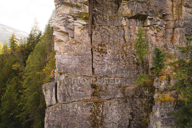 Entschlossener Bergsteiger erklimmt die felsige Klippe — Stockfoto