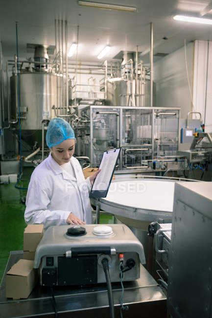 Female worker monitoring machine in the factory — Stock Photo