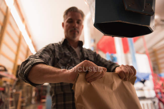 Чоловік упаковує вишукані зерна на заводі — стокове фото