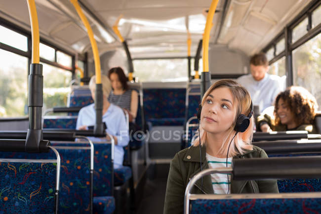 Жінка слухає музику під час подорожі в сучасному автобусі — стокове фото