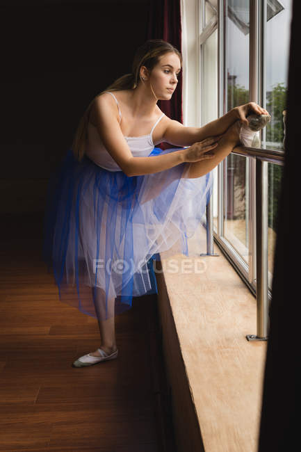 Ballerina practicing on the barre in dance studio — Stock Photo