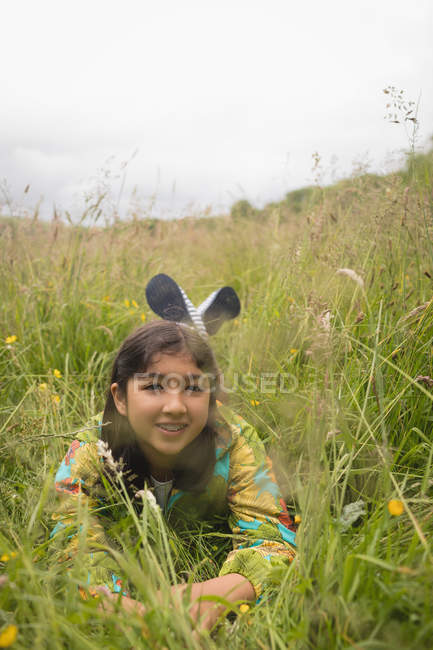 Happy girl lying on green grass — Stock Photo