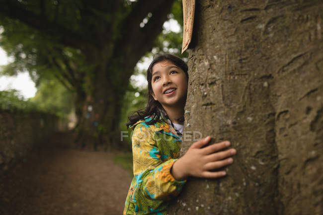 Chica joven abrazando el árbol - foto de stock