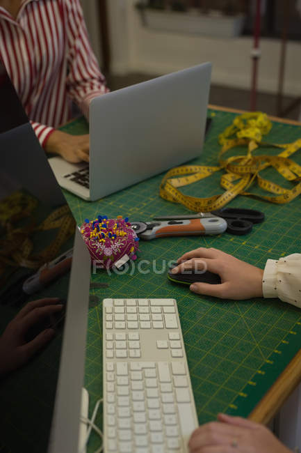 Designers de moda usando computador e laptop no estúdio de moda — Fotografia de Stock
