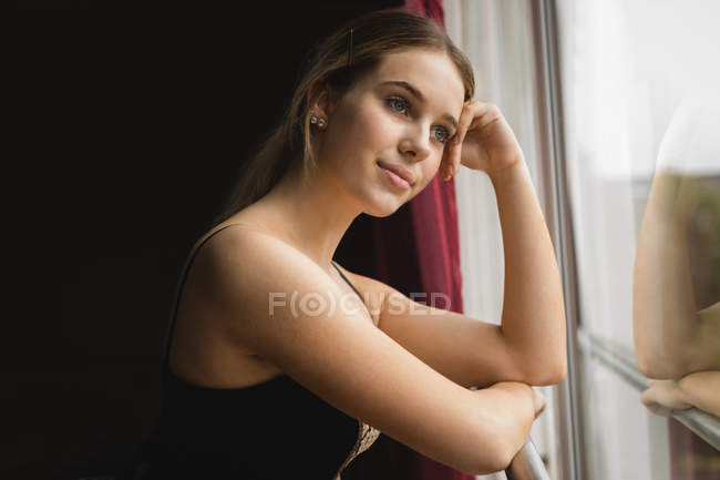 Ballerine réfléchie regardant par la fenêtre dans le studio — Photo de stock