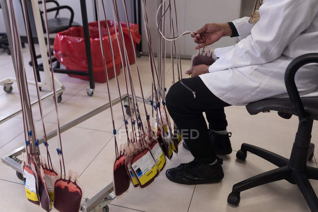 Técnico de laboratório analisando bolsa de sangue no banco de sangue — Fotografia de Stock